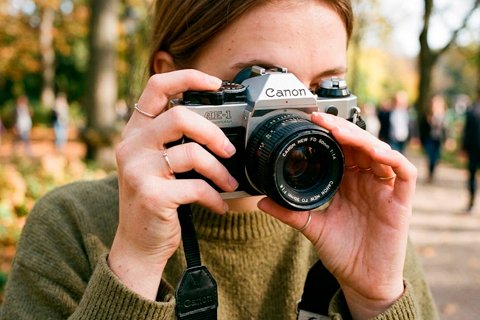 mujer sosteniendo cámara vintage